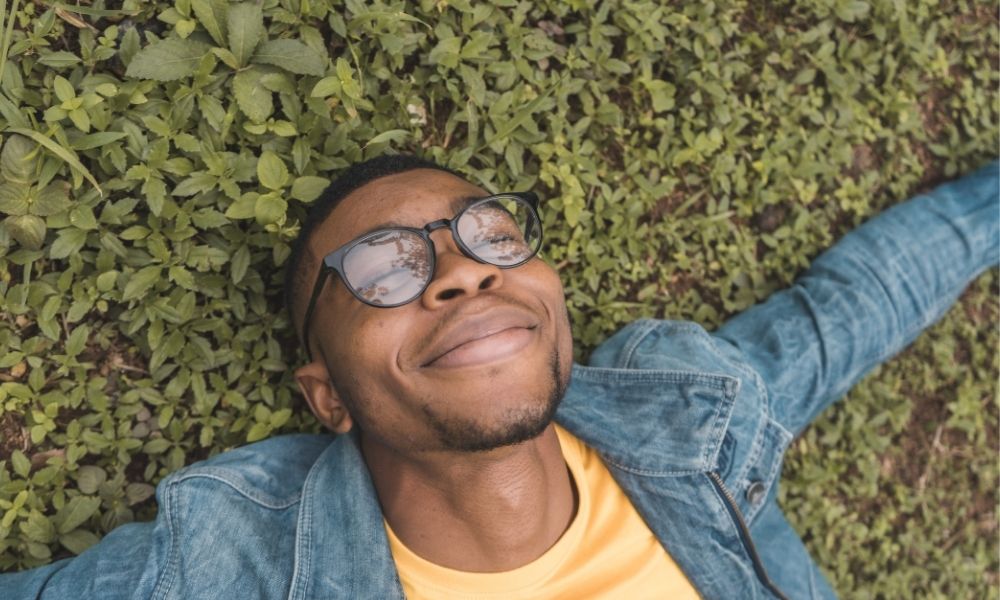 happy man lying in grassy field