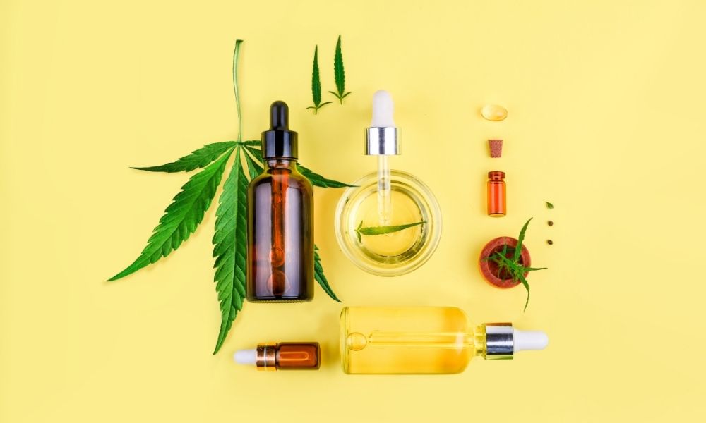cbd oil and leaves with yellow background