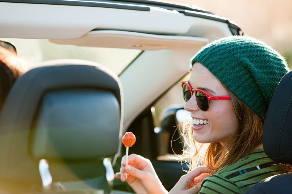 woman in convertible in green beanie