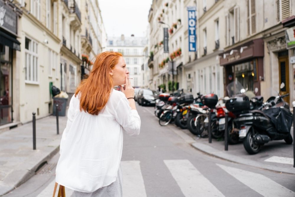 redhead woman smoking in the city