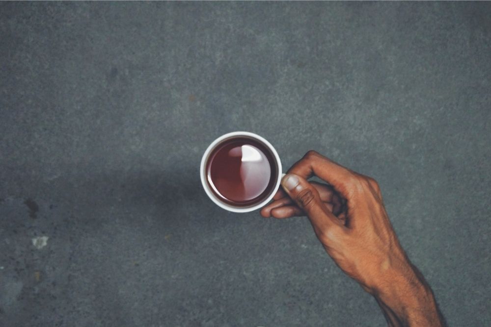 holding some tea with one hand