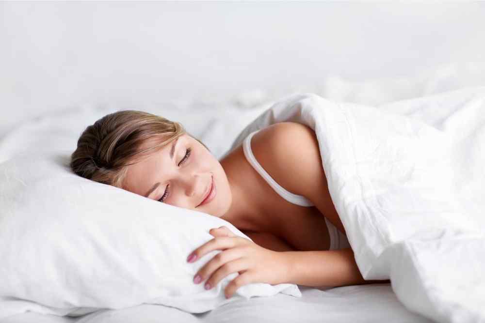 happy woman sleeping in cozy bed