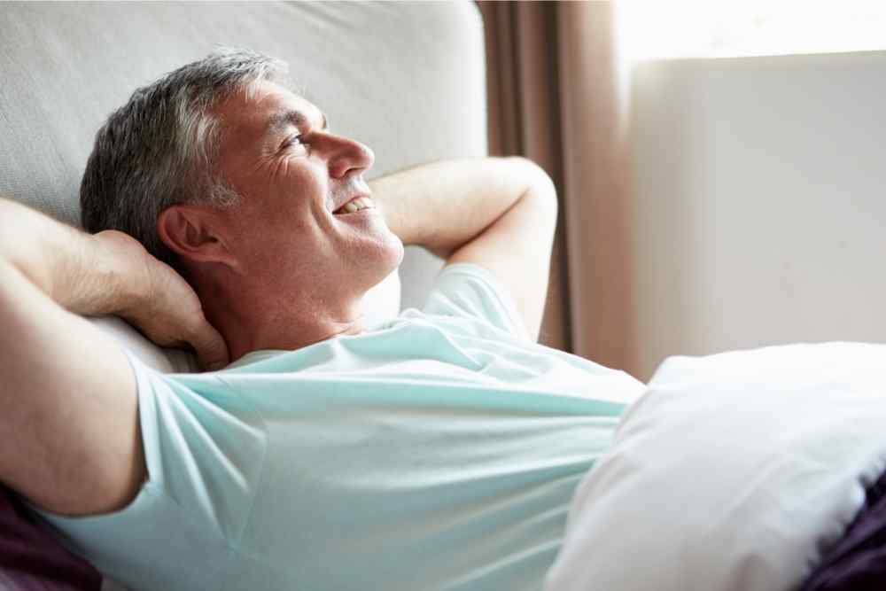 joyous man smiling happily in bed