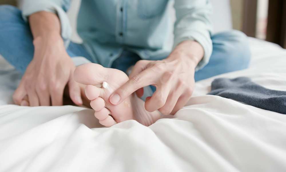 person inspecting bottom of foot