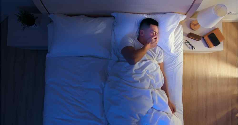 man in bed can't fall asleep