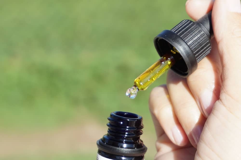 woman using cbd oil drops