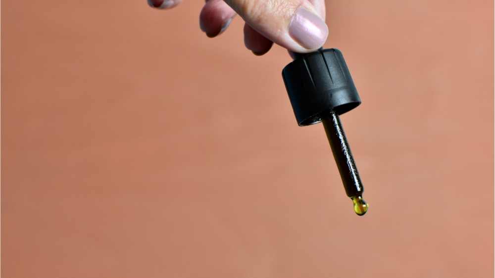 person holding oil dropper