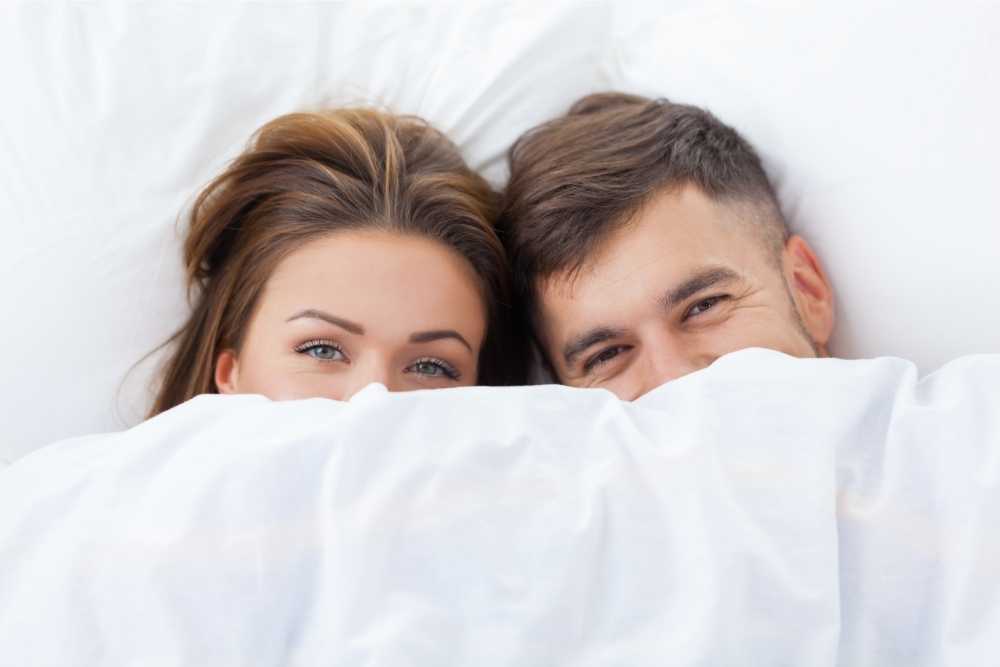 couple under the covers in bed