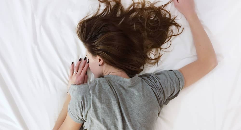 woman lying face down on bed